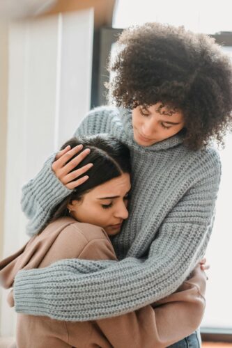 A woman and a teenage girl embracing