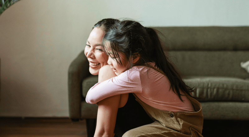 a child embraces their parents' shoulders